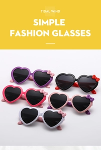 Flat lay of kids heart-shaped sunglasses with cute bow accents in five vibrant colors