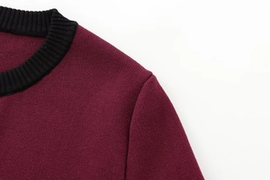 Detailed view of the burgundy knit sweater with a contrasting black ribbed crew neckline