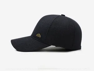 Detail view of winter baseball cap showing thick wool texture and metal mountain badge