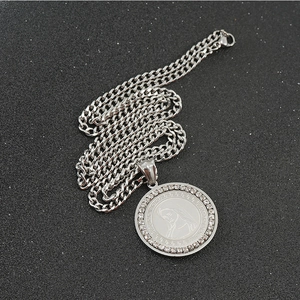 Macro shot of silver stainless steel necklace with round pendant and sparkling zircons