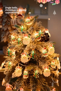 Detail of LED Christmas string lights featuring Santa Claus and tree shapes on snowy branches