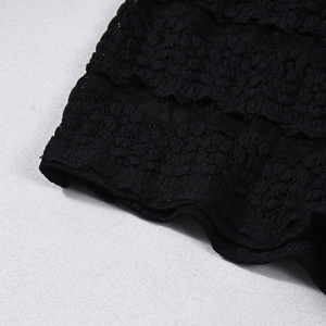 Nahaufnahme der schwarzen Spitze mit hohlen Blumenmustern auf den gestreiften Shorts