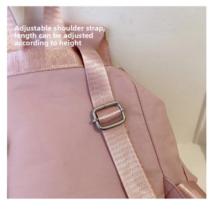 Detailed macro view of the pink backpack adjustable nylon strap with silver metal buckle