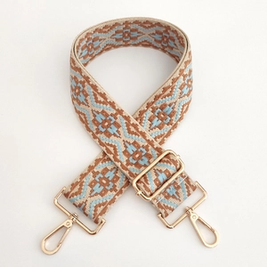 Detailed weave of geometric jacquard shoulder strap with gold-tone adjustable metal buckles