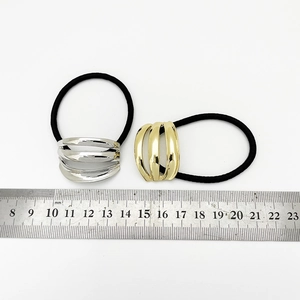 Macro view showing 3.5cm curved metal hair ties in gold and silver on scale