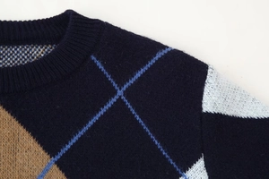Detailed close-up of navy blue diamond pattern neckline and soft knit texture