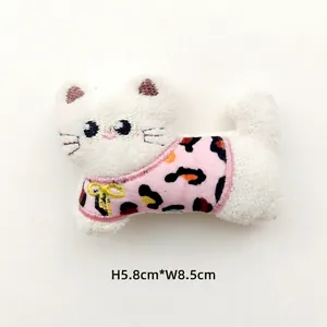 Detail view of plush leopard cat accessory with pink leopard print and yellow bow