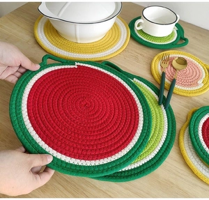 Macro detail of round woven cotton fruit placemat with handle for kitchen table heat protection