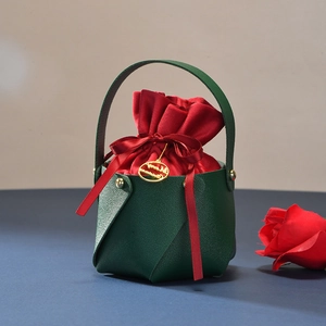Detail of green leather gift bag with red velvet pouch and Christmas gold tag