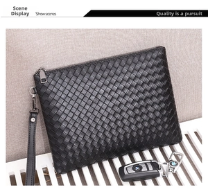 Macro detail of high-quality black woven leather texture and silver zipper on clutch bag