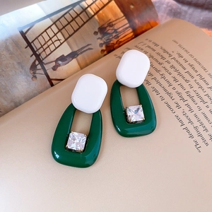 Macro detail of vintage green heart earrings with zircon on an English book page