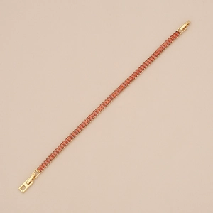 Détail d'un bracelet doré orné de zircons de couleur ambre de taille baguette raffinée