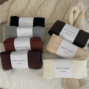 Flat lay of colorful knit socks in earth tones with stylish paper packaging bands