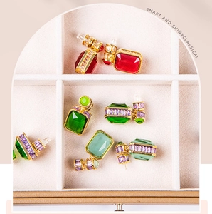 Macro view of vintage style geometric earrings with colorful gems and zircon pavé