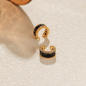 Detail of gold ear cuff with row-set black rectangular zircons and beaded edge texture