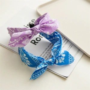 Detail of blue and purple paisley print knotted headbands on a magazine background