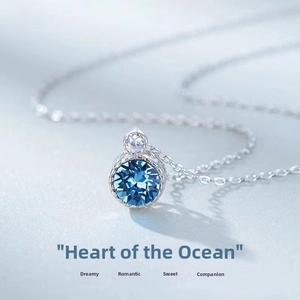 Detailed macro shot of the round deep blue crystal pendant on a silver-tone necklace chain