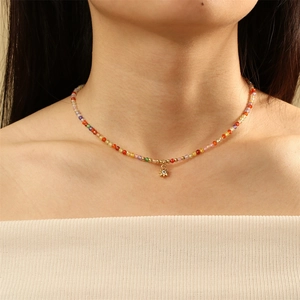 Detail of colorful tourmaline bead necklace featuring a golden sun pendant with zircon