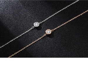 Macro detail of silver and rose gold bubble bracelets with round moissanite stones