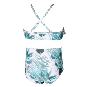 Detail of tropical palm leaf print bikini featuring adjustable cross-back straps and high waist