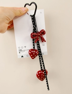 Detail of handmade red polka dot heart and bow charm with black heart carabiner