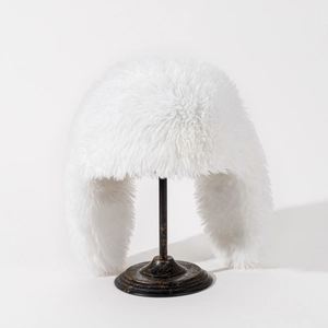 Detailed close-up of the plush faux fur texture on a white winter trapper hat