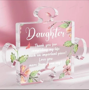 Macro detail of acrylic puzzle plaque with pink flowers and daughter quote on pink background