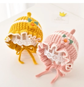 Detail of baby winter knit hats with flower decor, thick texture and ear protection
