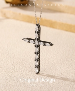 Close-up of a vintage black cross pendant with marquis-cut crystals and a silver chain
