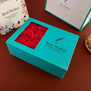 Blue gift box detail with six red soap roses and a matching Best Wishes paper bag