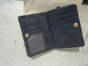 Detail view of open navy blue bifold wallet with multi-card slots and clear ID window