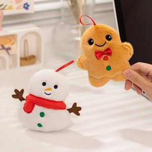 Detail showing plush snowman and gingerbread man Christmas ornaments with red lanyards
