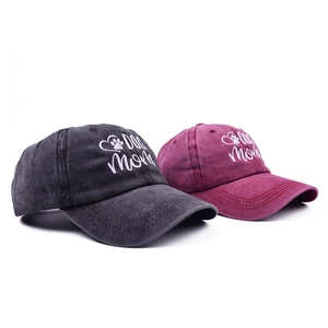 Detail of Dog Mom embroidery on washed cotton baseball caps in charcoal and burgundy