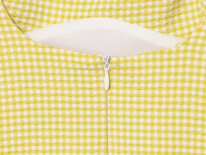 Detail of yellow and white gingham seersucker fabric with a hidden zipper closure