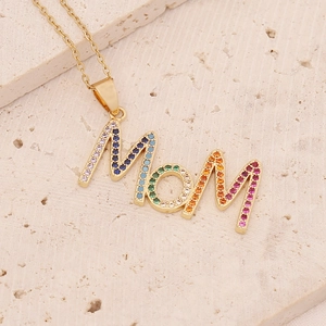 Detail of gold Mom pendant with multi-colored cubic zirconia on natural stone