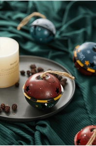 Close-up of vintage metal Christmas bell ornaments with star cutouts and hemp rope hanging