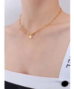 Close-up of golden paperclip chain necklace with minimalist star pendant on neck