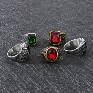 Close-up of vintage steel rings with red, blue and green gemstones and floral carvings