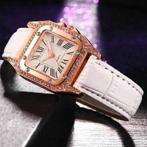 Close-up of square rose gold watch with sparkling rhinestones and white leather strap