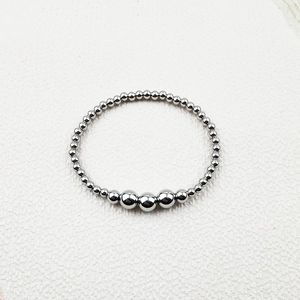 Detailed view of silver stainless steel beads and faceted crystals on a handmade elastic bracelet