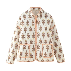 Close-up of vintage floral quilted jacket with standing collar and symmetrical pockets