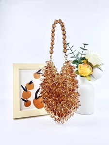 Detail of amber acrylic teardrop beads on a handmade clutch bag with round bead handle