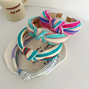 Detail of colorful striped knotted headbands in satin finish with elastic band design