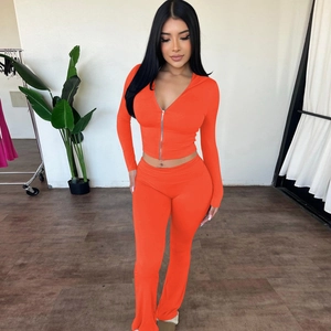 Detailed shot of orange hooded zip-up sweatshirt and high-waist flare trousers set