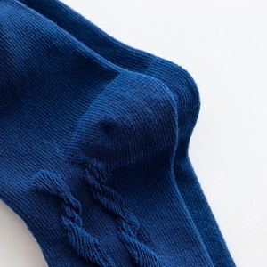 Detailed macro view of the knitted texture and heel part of dark blue Lolita style socks