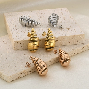 Detailed close-up of spiral hollow teardrop earrings in silver, gold, and rose gold finish