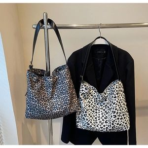 Detail showing high-capacity leopard print tote bags in dark brown and black white patterns