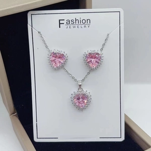 Detail of pink heart-shaped zircon jewelry set on a white display card in a gift box