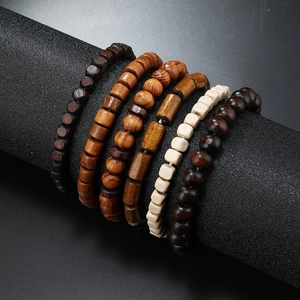 Detail shot of multi-style wooden beaded bracelets on a black jewelry display stand