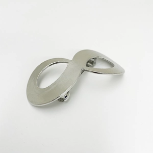 Detailed close-up of a silver figure-eight metal hair clip with textured metallic finish
